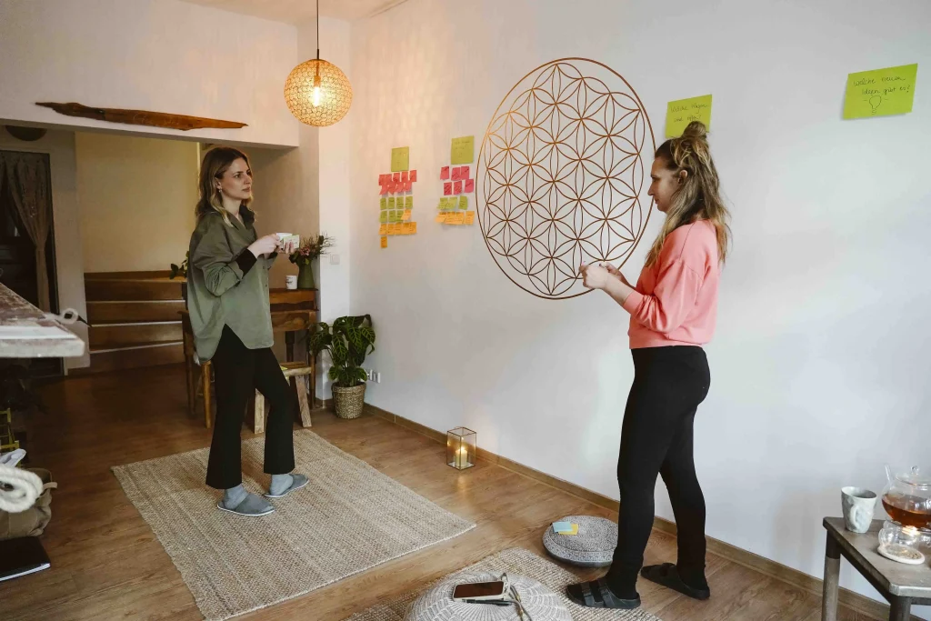 Zwei Frauen unterhalten sich über die Post-Its, die sie an die Wand gehängt haben